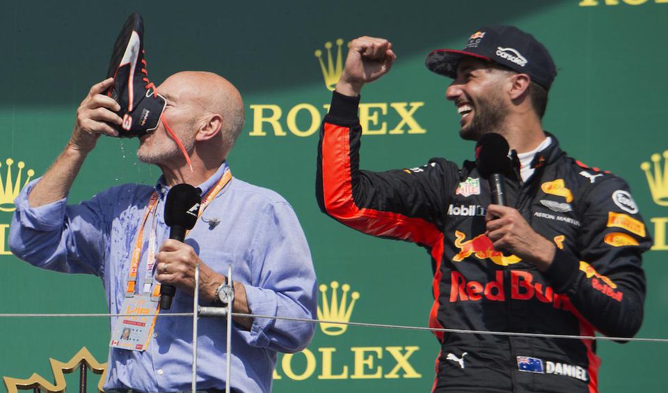 Patrick Steward a Daniel Ricciardo na pódiu pijú šampanské z topánky.