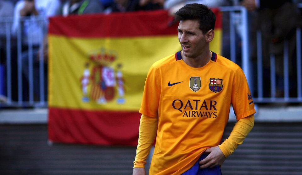 Lionel Messi, FC Barcelona, zlty dres, spanielska vlajka v pozadi, Feb2016