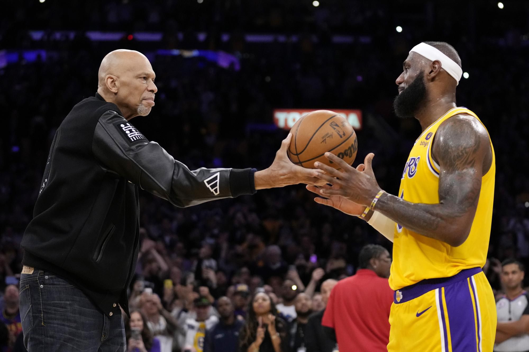 Kareem Abdul-Jabbar (vľavo) takto odovzdával loptu LeBronovi Jamesovi po tom, čo ho prekonal na čele historického rebríčka strelcov.