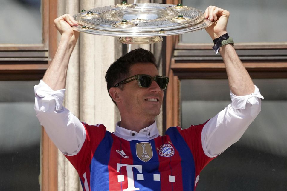 Futbalista Bayernu Mníchov Robert Lewandowski pózuje s trofejou na balkóne radnice počas osláv zisku 31. majstrovského titulu v nemeckej Bundeslige