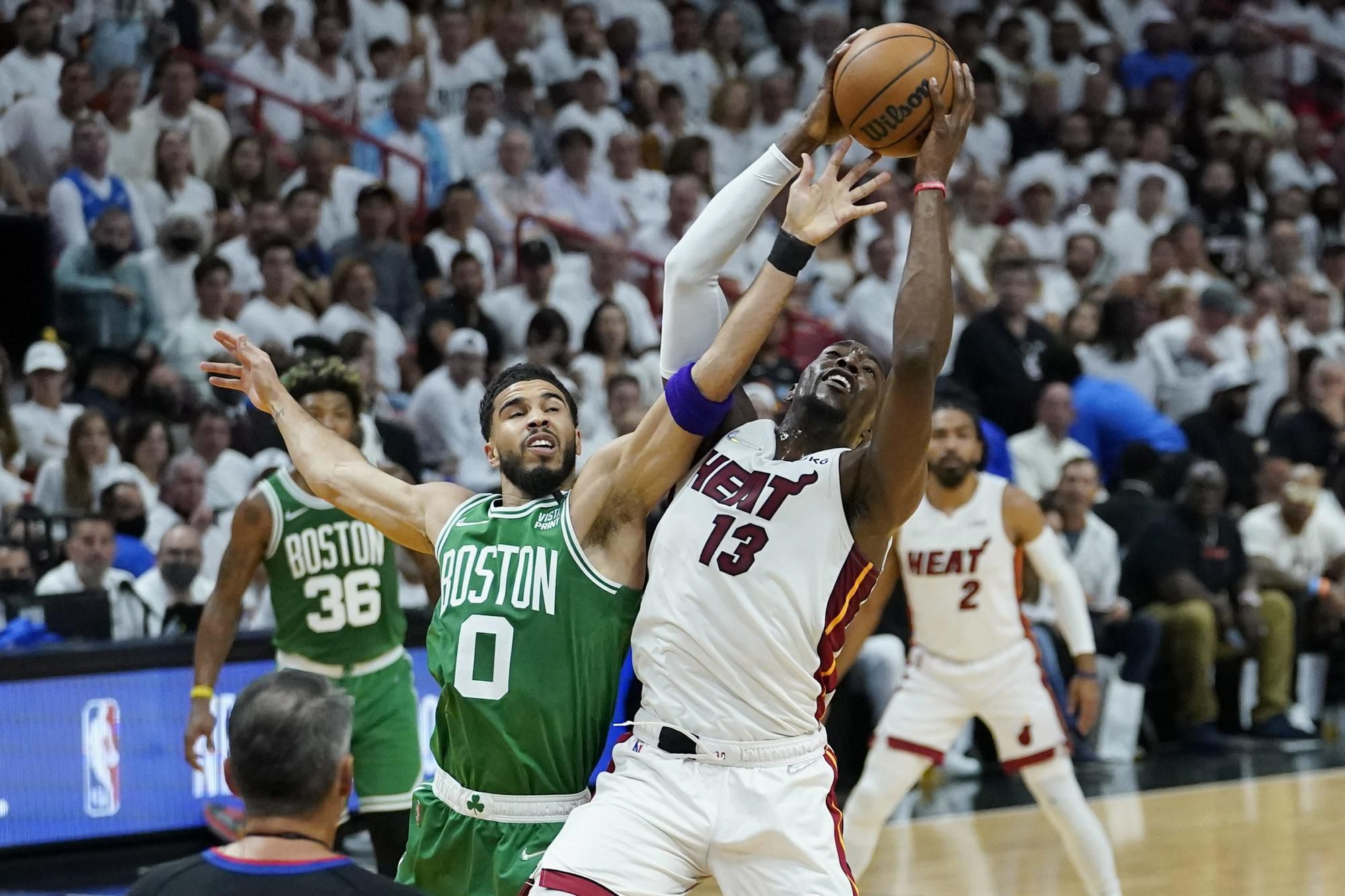 Hráč Bostonu Celtics Jayson Tatum a vpravo Bam Adebayo z Miami Heat bojujú o loptu.