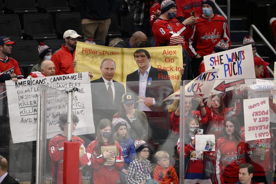 Fanúšikovia držia transparent s fotkou ruského prezidenta Vladimira Putina a hokejistu Alexandra Ovečkina.
