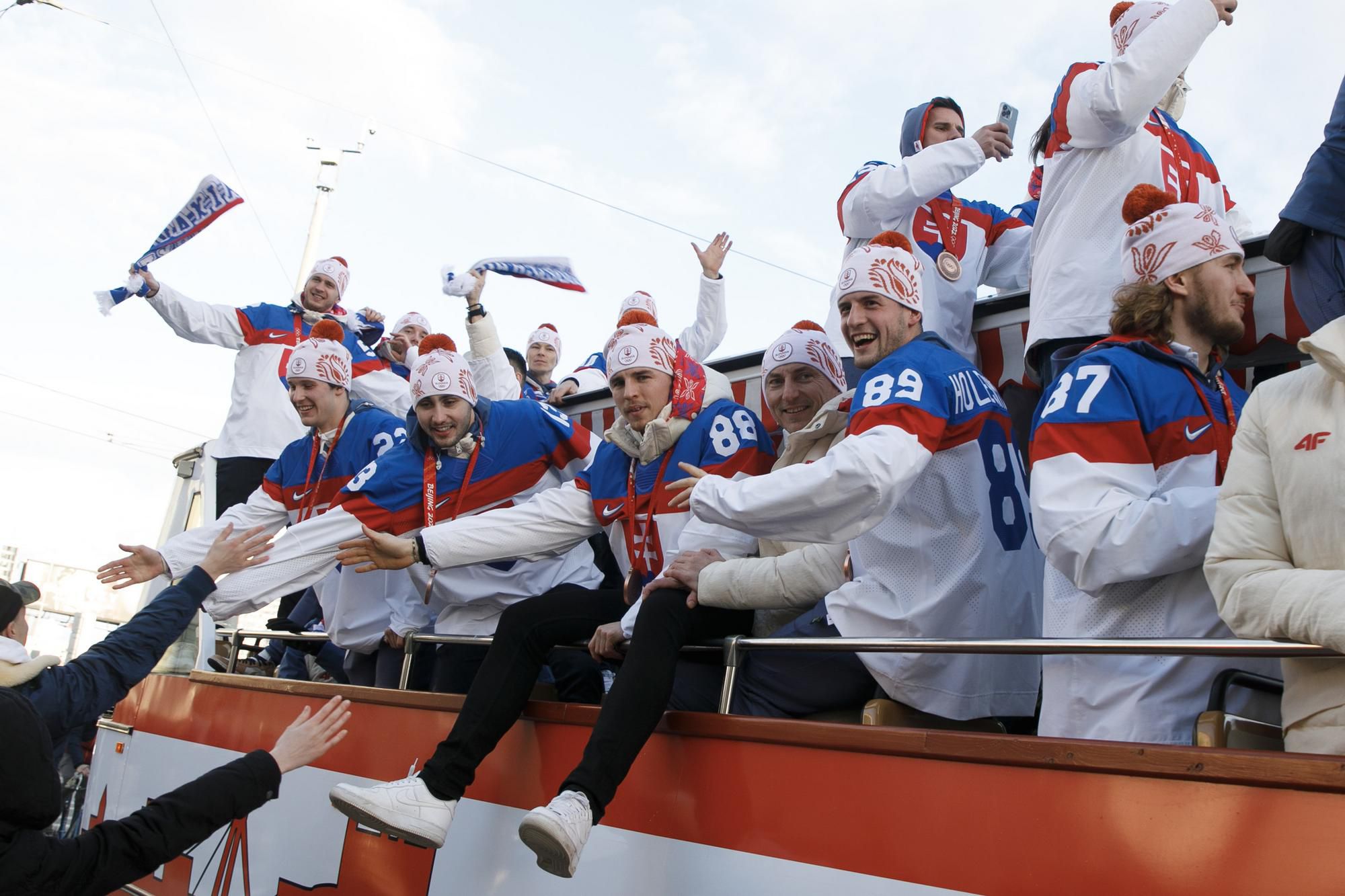 Fanúšikovia zdravia hokejistov počas ich okružnej jazdy kabrioautobusom v uliciach Bratislavy.