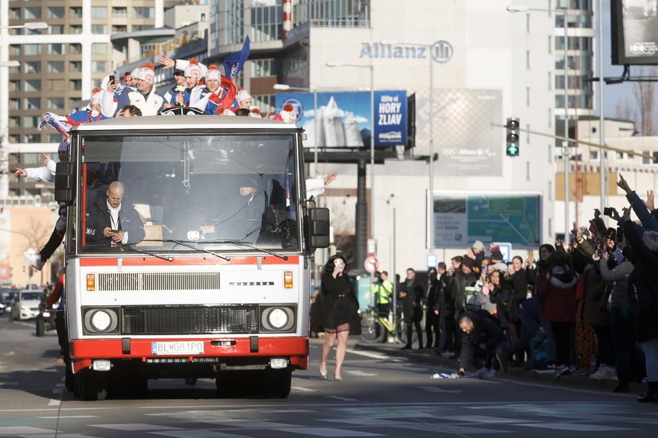 Fanúšikovia zdravia hokejistov počas ich okružnej jazdy kabrioautobusom v uliciach Bratislavy.