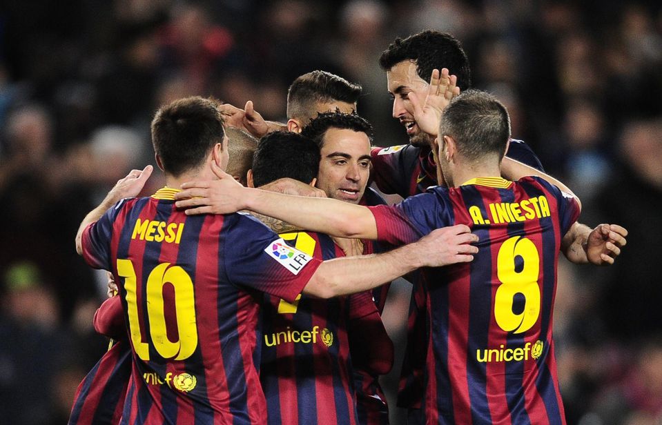 Xavi v obklopení hráčov FC Barcelona v roku 2014