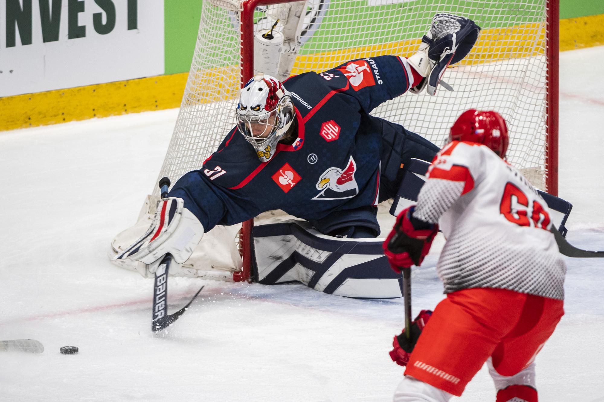 zľava brankár Kristers Gudlevskis (Slovan) a Roman Szturc (Třinec) počas zápasu F-skupiny Ligy majstrov