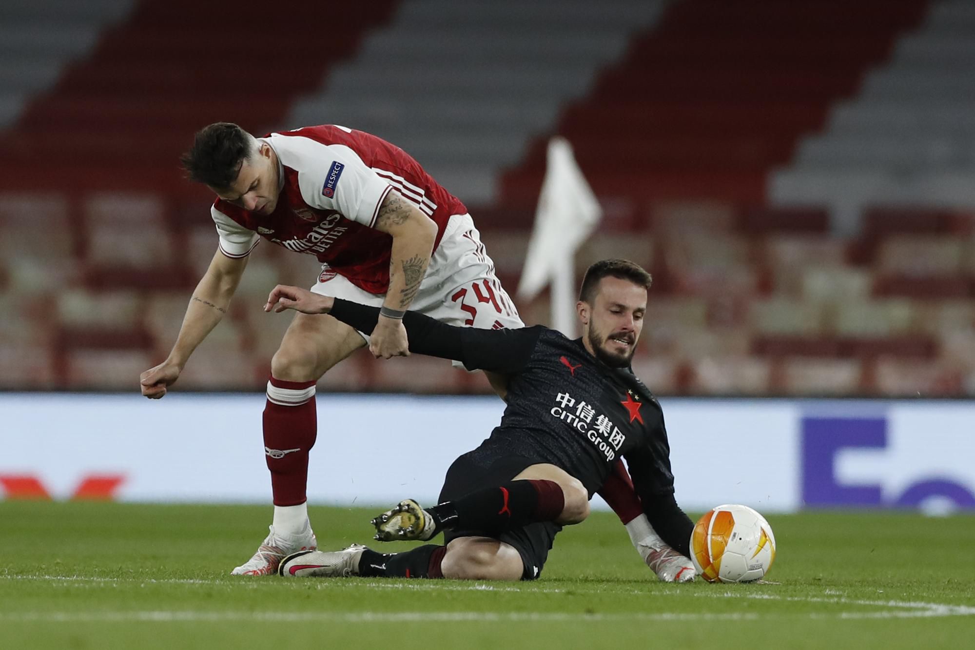 Hráč Arsenalu Granit Xhaka (vľavo) zastavuje Slováka Jakuba Hromadu zo Slavie Praha  v zápase štvrťfinále Európskej ligy