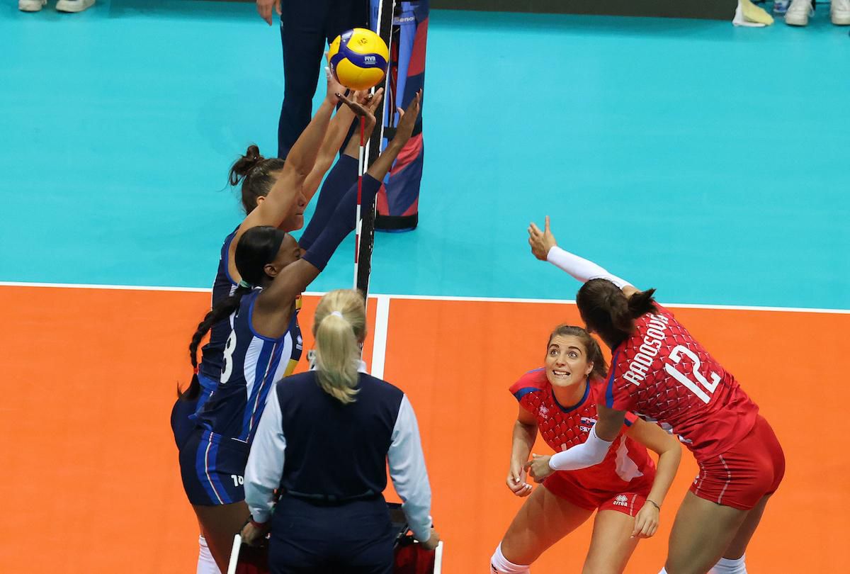 Slovenská hráčka Nikola Radosová (v červenom) smečuje.