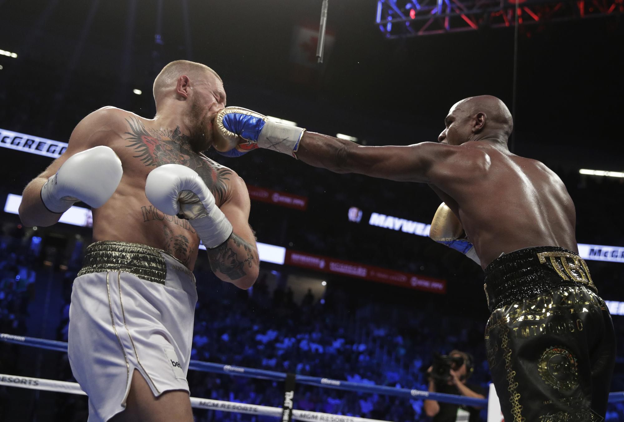 Floyd Mayweather zasahuje Conora McGregora.