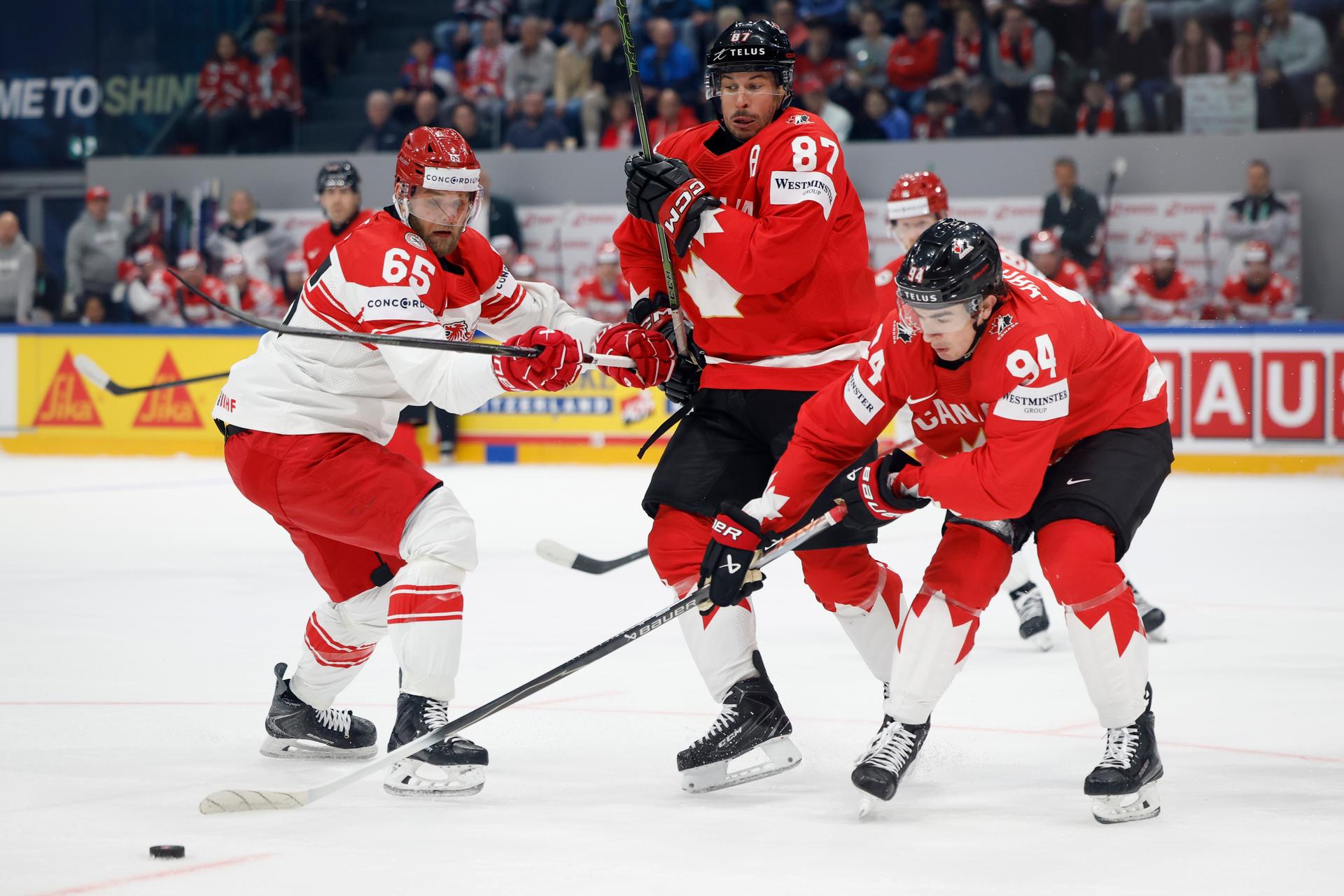 Zľava Christian Wejse (Dánsko),  Sidney Crosby a  Porter Martonen (obaja Kanada) na MS v hokeji 2026. Zdroj: SITA/AP