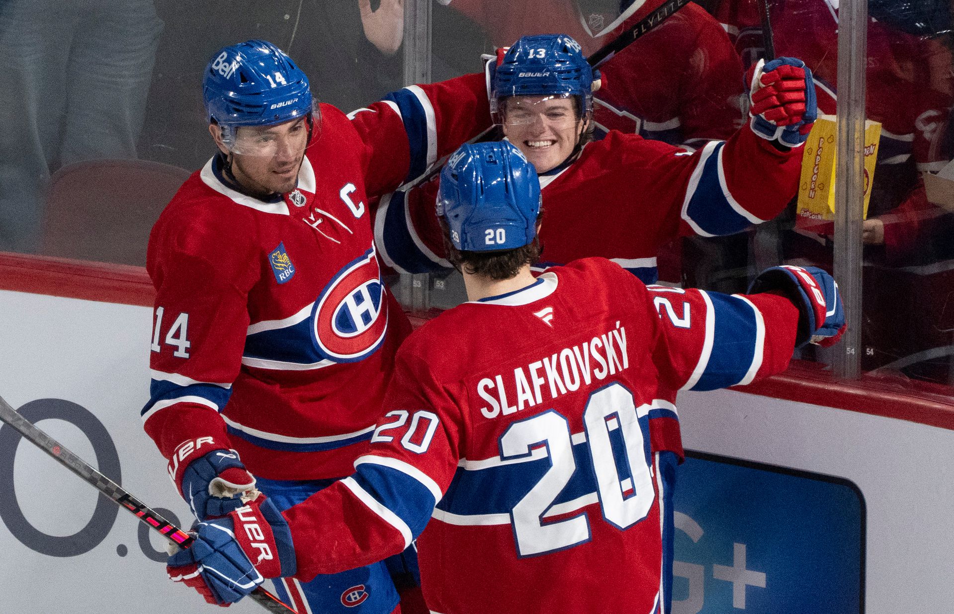 Hokejisti Montrealu Canadiens Cole Caufield, Nick Suzuki a Juraj Slafkovský sa tešia z gólu. Zdroj: SITA/AP