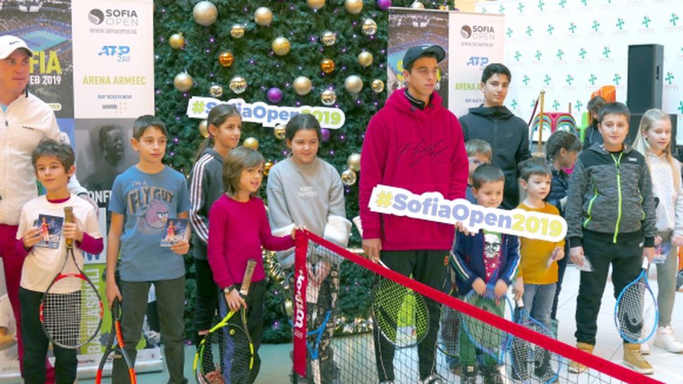 Адриан Андреев игра тенис с десетки деца под голяма коледна елха