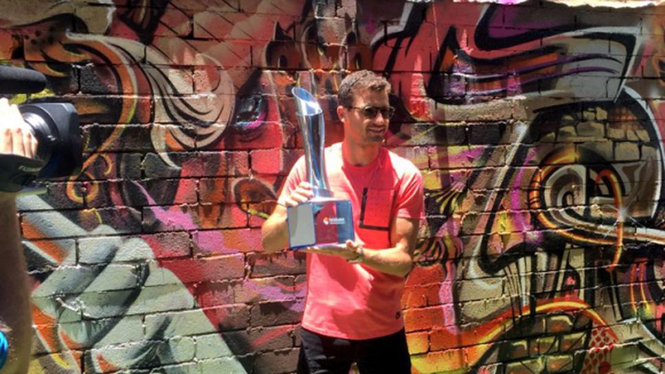 Григор позира пред графити с петия си трофей