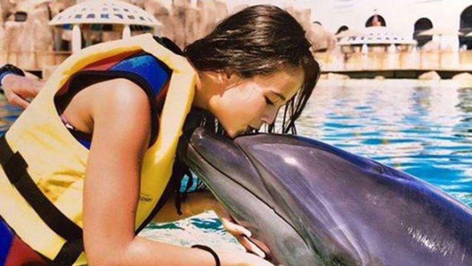 Гимнастичка целува делфин