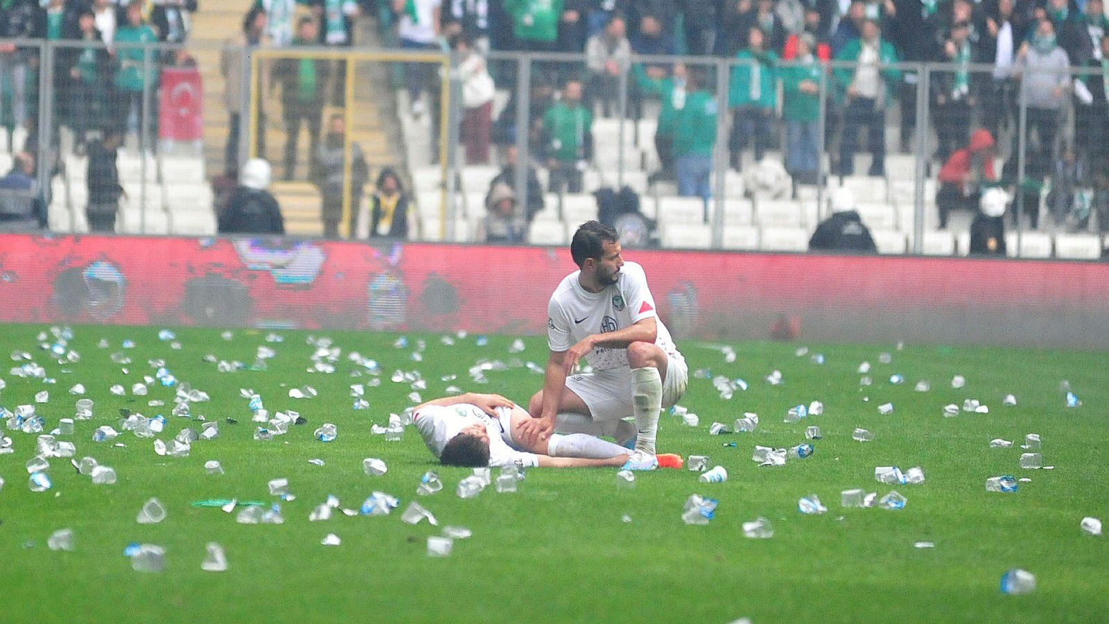 Műanyag poharak hevernek a pályán a játékosok körül... (Fotó: Twitter/Fotomac)