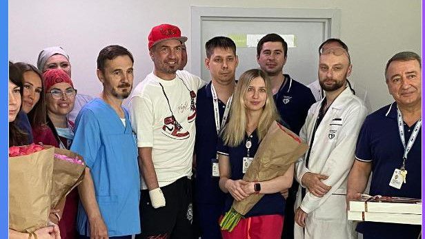 Piros sapkában a mosolygó bajnok, körülötte a kórház személyzete (Fotó: Instagram)