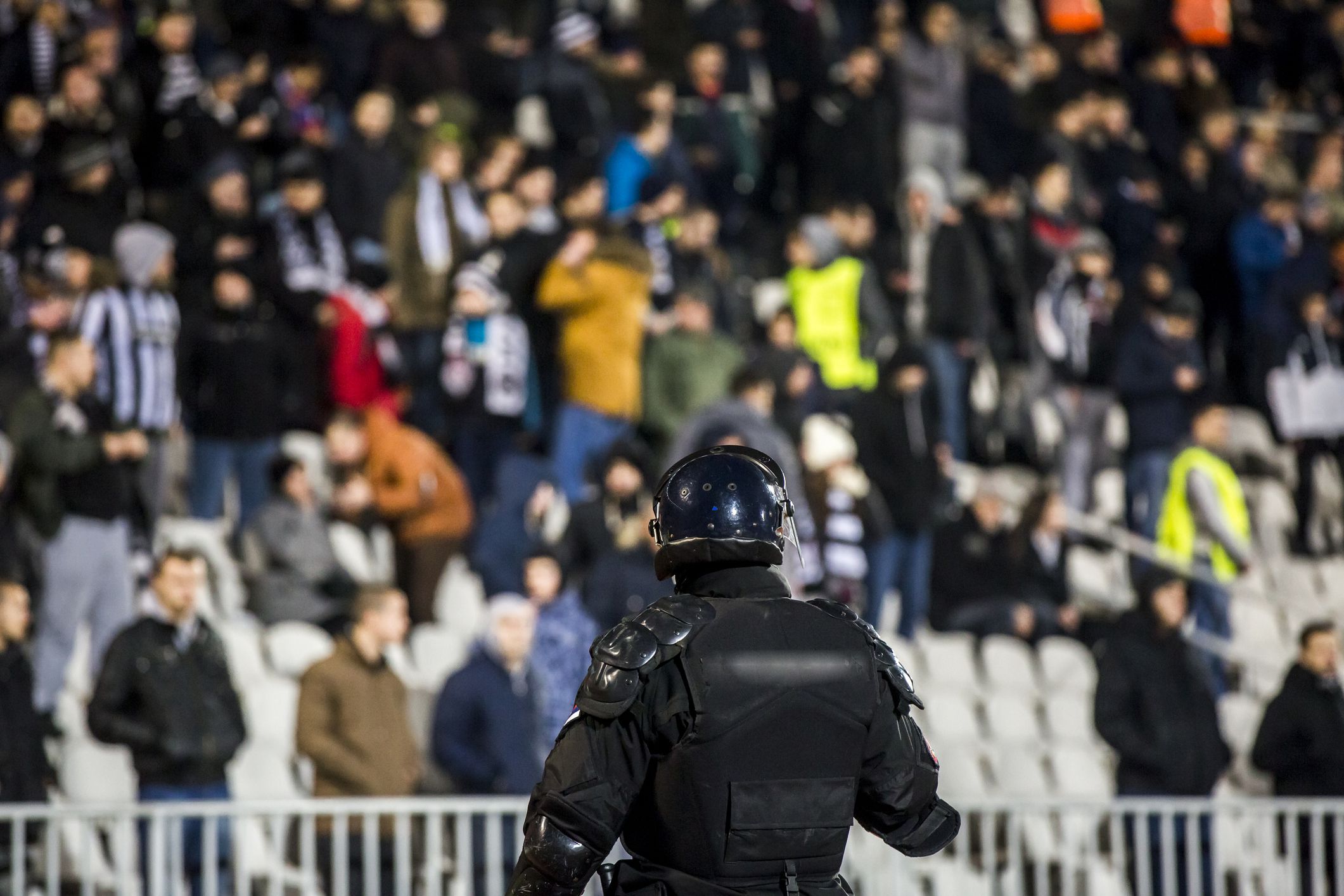 Szürreális jelenetek a futballpályán: videón, ahogy a rendőr a játékosok közé lő