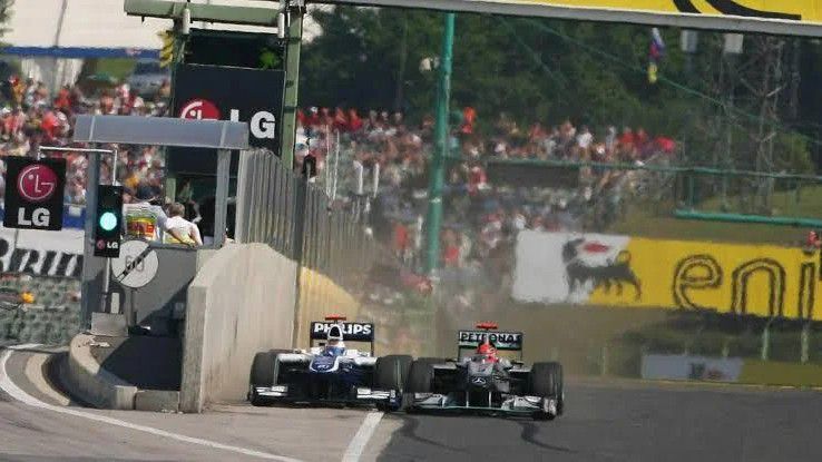 Rubens Barrichello megelőzné Michael Schumachert a Hungaroring célegyenesében a 2010-es Magyar Nagydíjon