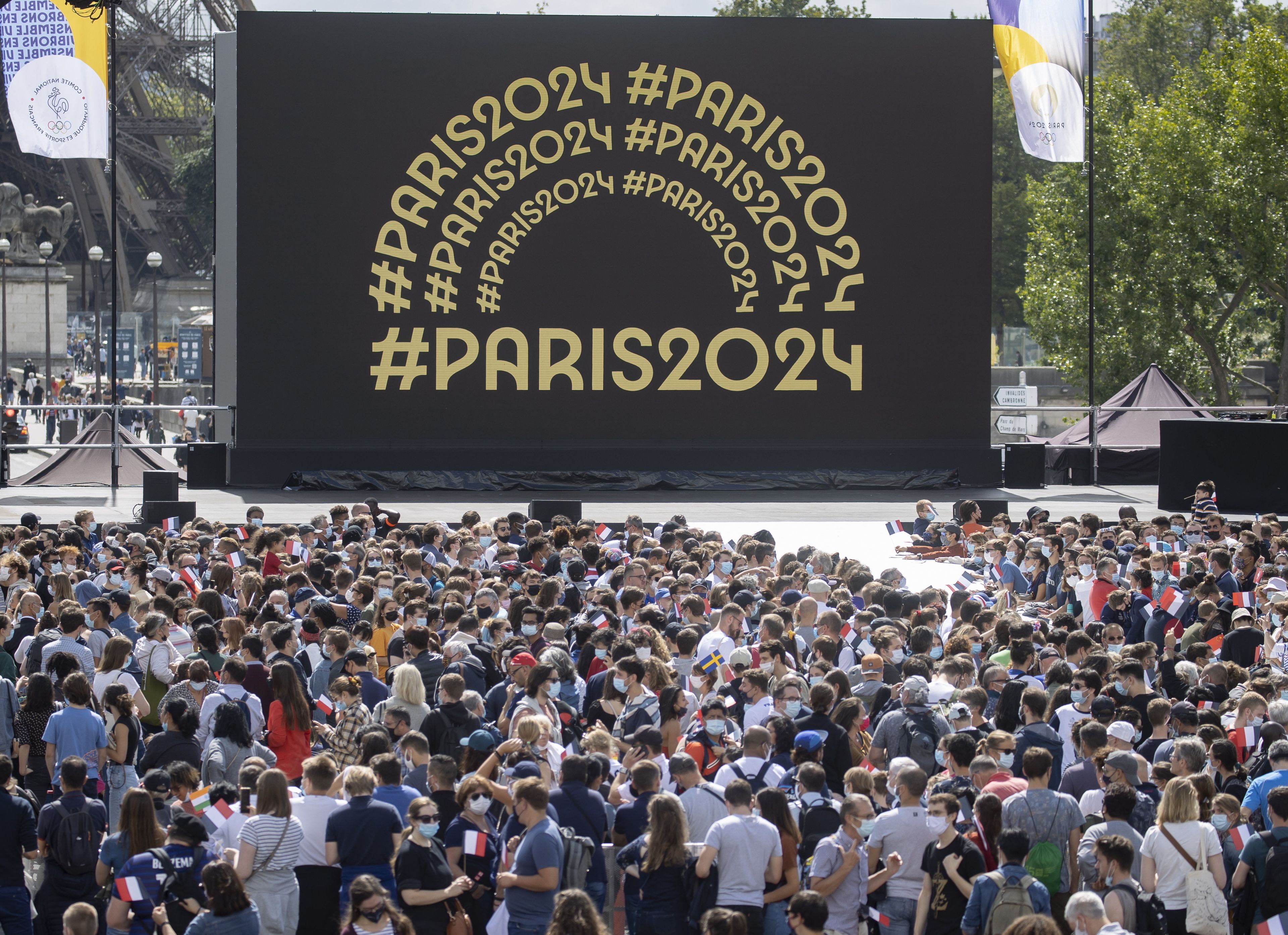 Az olimpiai szurkolói övezet látogatói a párizsi Eiffel-torony előtti Trocadero téren megünneplik, hogy a 2024-es nyári játékokat rendező Párizs átvette az olimpiai zászlót a japán fővárostól. / Fotó: MTI/EPA/Ian Langsdon