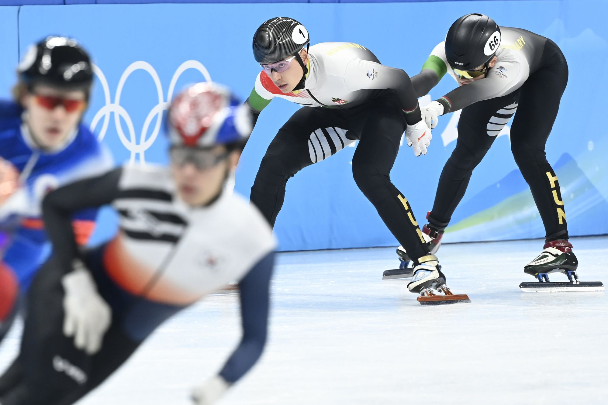 Liu Shaoang váltja Krueger John-Henryt a férfi rövidpályás gyorskorcsolyázók 5000 méteres váltóversenyének elődöntőjében a pekingi téli olimpián a Fővárosi Fedett Stadionban. / Fotó: MTI/Kovács Tamás
