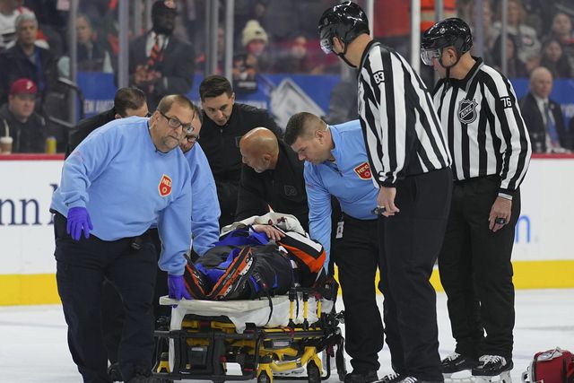 Mitch Dunning játékvezetőt hordágyon viszik el a Philadelphia–Colorado NHL-meccs első harmadában történt ütközés után (Fotó: Getty Images)