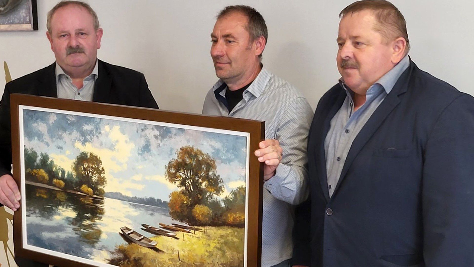A vezetőedző (középen) elbúcsúzott a Gyirmóttól, és a két tulajdonostól kapott egy festményt ajándékba. (Fotó: gyirmotfc.hu)