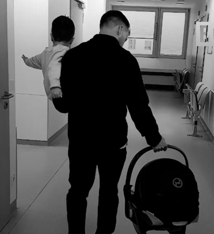Elkapott kórházi fotó: a világbajnok futballista bal karján Rome-mal, jobb kezében a babahordóban meg az újszülött kislánnyal
