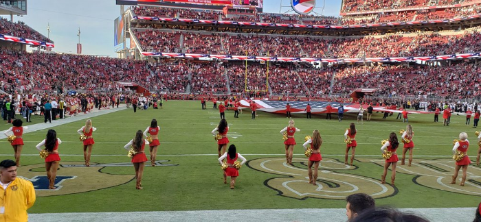 Cheerleader protesteert op een knie tijdens Amerikaans volkslied