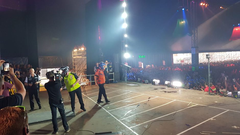 Van Gerwen en Barney darten met brillen en helmen op (video)