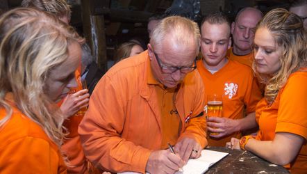 Oranjefans rouwen in Hannover met biertje in de hand