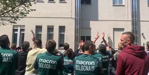 🎥​ | Selectie Bologna zingt bij ziekenhuis aan leukemie lijdende trainer toe
