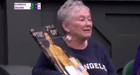 🎥 | Oudere dame in Wimbledon-publiek houdt poster van ontblote Djokovic vast
