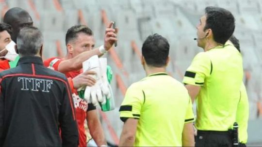 Turkse speler duwt telefoon met bewijs van fout onder de neus van scheidsrechter en krijgt rood
