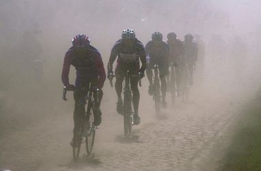 Hier kijk je naar (de contouren van) Mathieu van der Poel in de stofwolken van Parijs-Roubaix