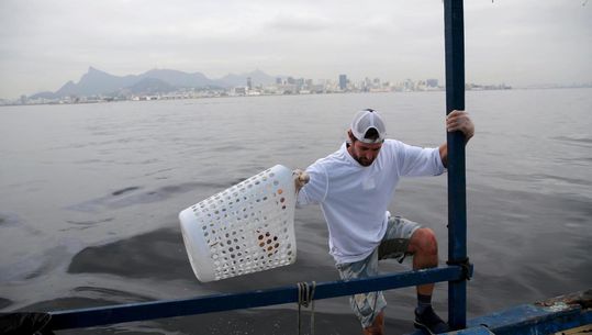 Amerikaanse zeiler vist troep uit Olympisch water