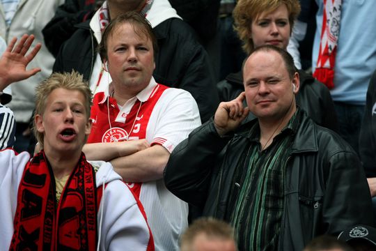 Gewapend met afstandsbediening, telefoon en radio kijken naar de eredivisie