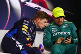 Max Verstappen kijkt mee op de telefoon van Fernando Alonso. © Getty Images