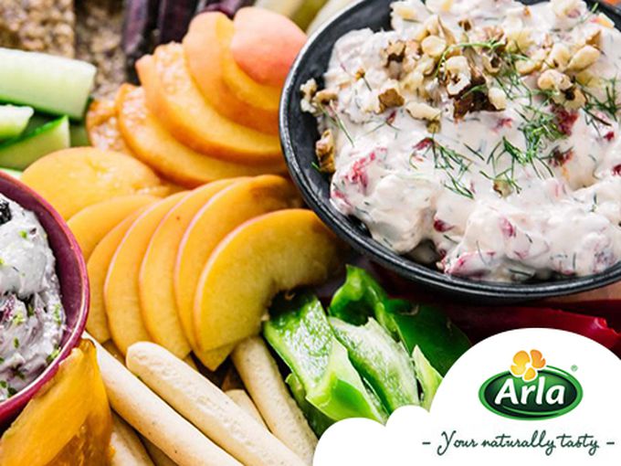 Цветна дъска с плодове, зеленчуци, крекери и два вида чийз дип