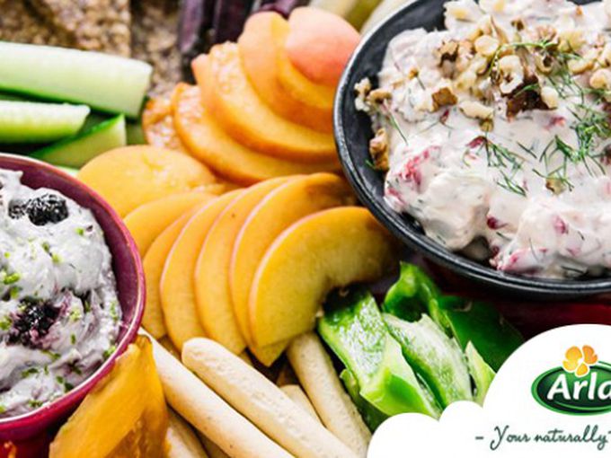 Цветна дъска с плодове, зеленчуци, крекери и два вида чийз дип