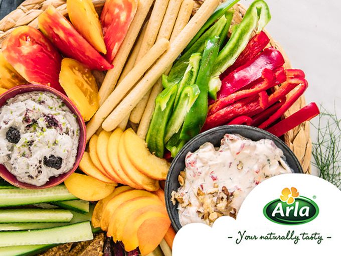 Цветна дъска с плодове, зеленчуци, крекери и два вида чийз дип